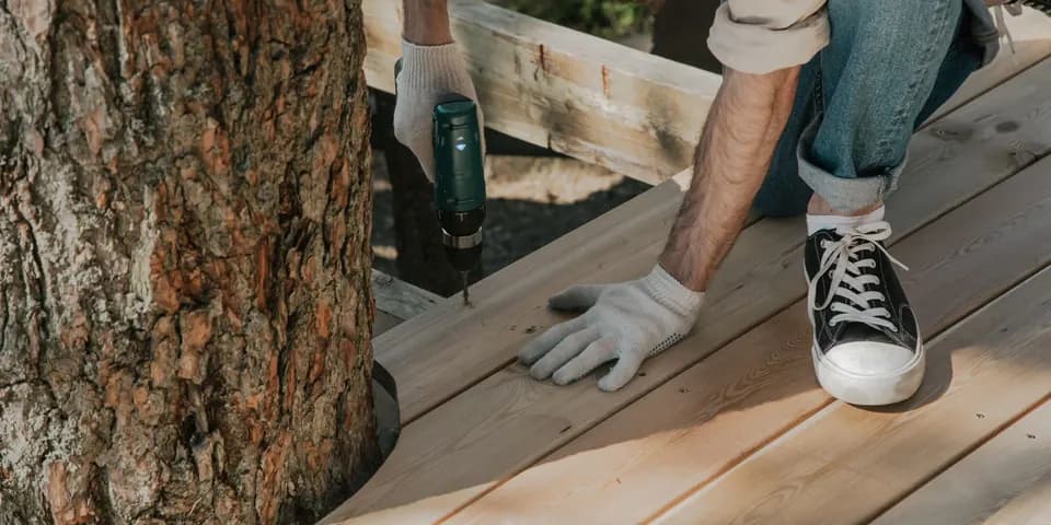 A builder screwing down new deck boards