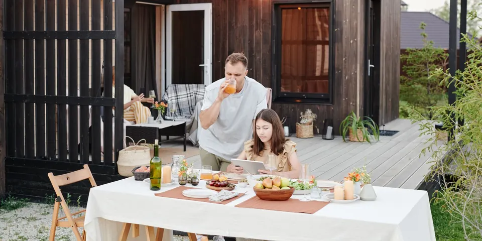 A couple eating dinner on their backyard deck